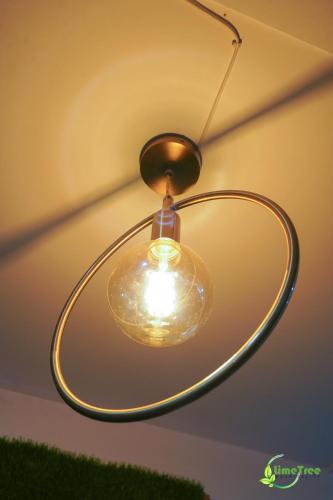 a glass light fixture hanging from a ceiling at Lime Tree Hotel Near 32nd Avenue Sector 29 Gurgaon in Gurgaon