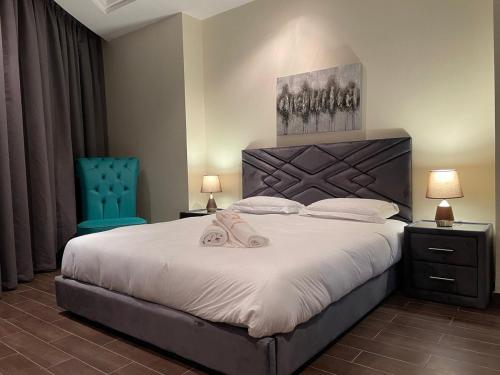 a bedroom with a large bed and a blue chair at Luxury Hotel Apartment Mall of Emirates in Dubai