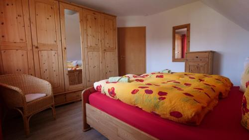 Schlafzimmer mit einem Bett, einem Stuhl und Schränken in der Unterkunft Ferienwohnung Amanda 1 in Bad Zwischenahn