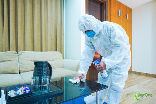 a person in a room wearing ansicsnsicsnsics suit andacist at Lime Tree Hotel Near 32nd Avenue Sector 29 Gurgaon in Gurgaon