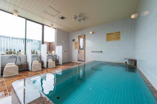 a large swimming pool in a room with a large window at Hotel Ikkeikaku in Kesennuma