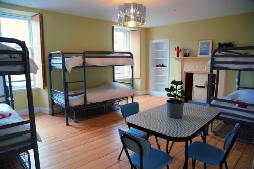 Camera con tavolo, sedie e letti a castello. di The Dolphin Inn Hostel a Dunbar