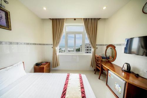 a bedroom with a bed and a television and a window at Binh Minh Hotel in Vung Tau
