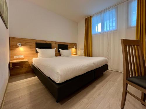 um quarto com uma cama grande e uma janela em Hotel Gute Hoffnung Pforzheim em Pforzheim