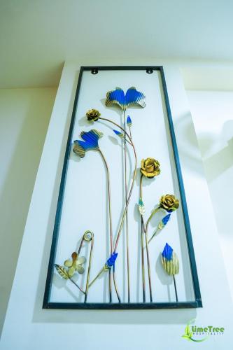 a glass display of flowers in a glass case at Lime Tree Hotel Near 32nd Avenue Sector 29 Gurgaon in Gurgaon