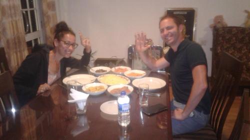 a man and a woman sitting at a table with food at Zion in Nuwara Eliya