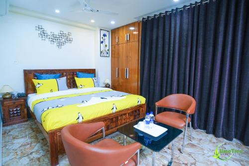 a bedroom with a bed and two chairs at Lime Tree Hotel Near 32nd Avenue Sector 29 Gurgaon in Gurgaon