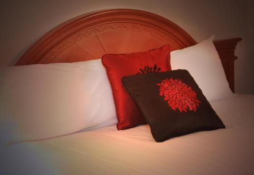 a bed with two red pillows on top of it at Ramada by Wyndham Medicine Hat in Medicine Hat