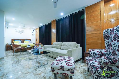a living room with a couch and chairs at Lime Tree Hotel Near 32nd Avenue Sector 29 Gurgaon in Gurgaon