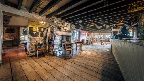 Un restaurante con una pared de piedra y mesas y sillas. en The Sheppey, en Glastonbury