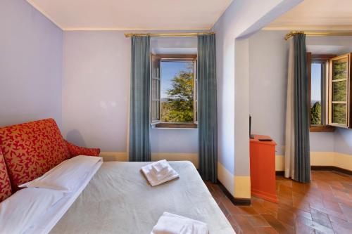 een slaapkamer met een bed en 2 ramen bij Villa Castiglione in Impruneta