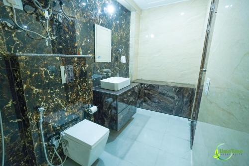 a bathroom with a shower and a toilet and a sink at Lime Tree Hotel Near 32nd Avenue Sector 29 Gurgaon in Gurgaon
