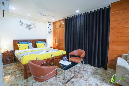 a bedroom with a king sized bed and chairs at Lime Tree Hotel Near 32nd Avenue Sector 29 Gurgaon in Gurgaon