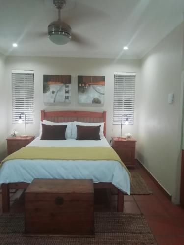 a bedroom with a large bed and two night stands at 4 Michael Place in Edenvale