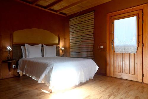 a bedroom with a white bed and a window at Casal da Serra in Penha Garcia