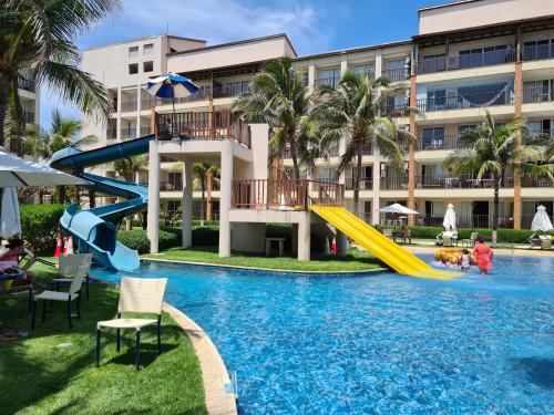 a swimming pool with a slide in a resort at Beach Living Vista Mar - 3 Quartos - Pé na Areia in Aquiraz