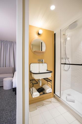 a bathroom with a sink and a shower at Hôtel Life Bordeaux Gare - BG in Bordeaux