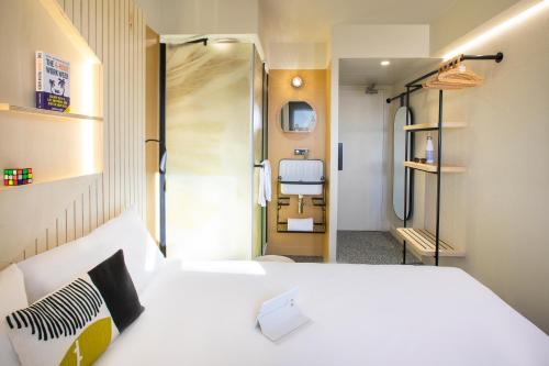 a small room with a bed and a bathroom at Hôtel Life Bordeaux Gare - BG in Bordeaux