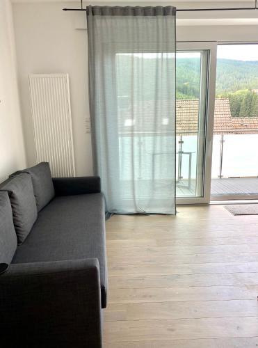 a living room with a couch and a large window at Exklusive 82 qm Loftwohnung mit Tiefgarage und Süd-Balkon zentral in Titisee-Neustadt