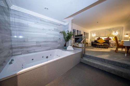 a large bathroom with a tub and a living room at Best Western Plus White Horse Hotel in Derry Londonderry