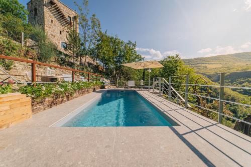 a swimming pool on the side of a house at MarcheAmore - La Roccaccia relax, art & nature in Montefortino