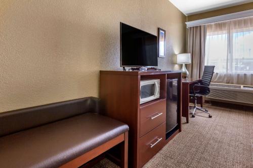 a hotel room with a tv on a dresser with a microwave at Comfort Inn & Suites in Deming