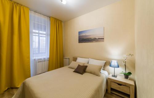ヤロスラヴリにあるDynasty apartmentsのベッドルーム1室(ベッド1台付)、黄色いカーテン付きの窓が備わります。