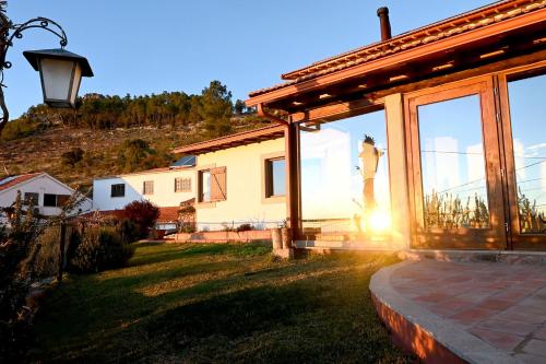 a house with the sun shining through the windows at Casal da Serra in Penha Garcia