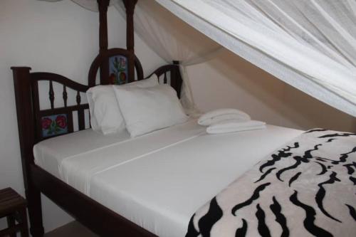 a bed with two white pillows on top of it at Safina Resort in Zanzibar City