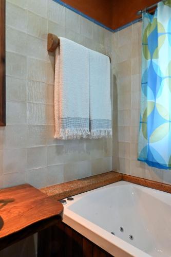 a bathroom with a white tub and a towel at Casal da Serra in Penha Garcia