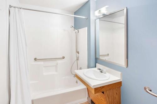 La salle de bains est pourvue d'un lavabo et d'une douche. dans l'établissement WoodSpring Suites Brownsville, à Brownsville