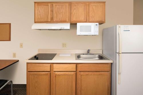 a kitchen with a sink and a refrigerator at WoodSpring Suites Brownsville in Brownsville