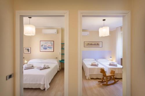 バルドリーノにあるResidence Ai Vigneti With Poolのベッド2台、テーブル2台、鏡が備わる客室です。