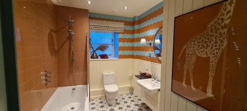 a bathroom with a giraffe painted on the wall at The Glenmorangie House in Tain