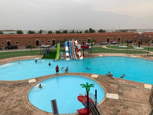 a large swimming pool with people playing in it at Hotel & Resort Golden Marina Yanbu in Yanbu