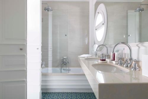 a white bathroom with two sinks and a tub at Villa Magalean Hotel & Spa in Hondarribia