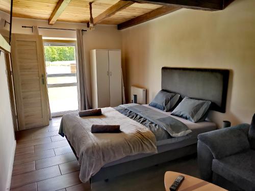 a bedroom with a large bed and a couch at Agrochalupki in Korczowa