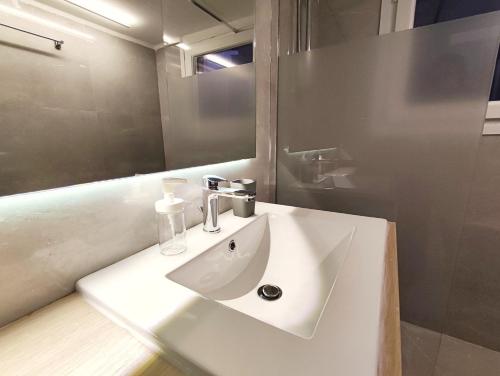 a bathroom with a white sink and a mirror at Veno Apartments Goudi in Athens