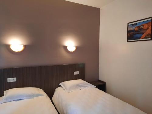 a room with two beds and two lights on the wall at Domaine du Bocage in Chavagnes-en-Paillers
