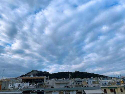 a group of buildings under a cloudy sky at Athens Skylight Condo in Athens