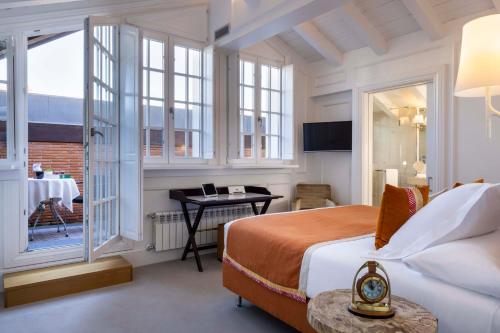 a bedroom with a bed and a desk and a window at Villa Magalean Hotel & Spa in Hondarribia