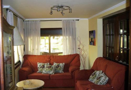 ein Wohnzimmer mit einem orangenen Sofa und einem Fenster in der Unterkunft Casa Nueva de Bueu in Bueu