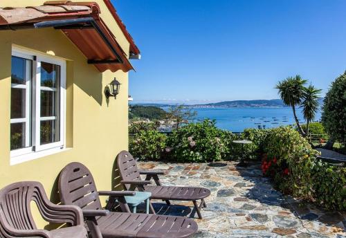 a patio with chairs and a table and a view of the water at Casa Vieje de Bueu in Bueu