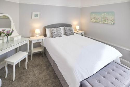 sypialnia z białym łóżkiem, biurkiem i lustrem w obiekcie Host & Stay - The Glaisdale at Brunswick Holiday Apartments w mieście Whitby