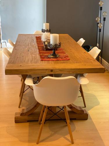 a wooden table with a white chair and candles on it at Waves Edge CP3 in Cape Town