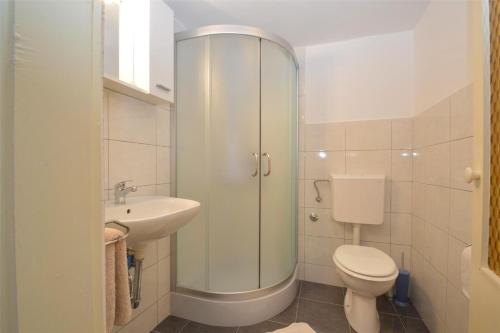 a white bathroom with a toilet and a sink at House Adriatic in Cunski