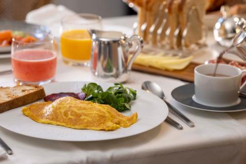 a breakfast table with a plate of eggs and greens and toast at Villa Magalean Hotel & Spa in Hondarribia