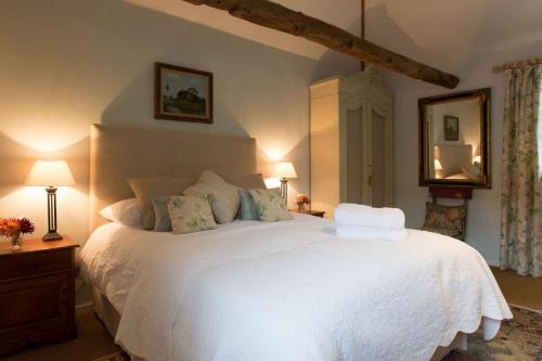 una camera con letto bianco e specchio di The Stables, relax in 5 star style and comfort with lovely walks all around a Great Maplestead