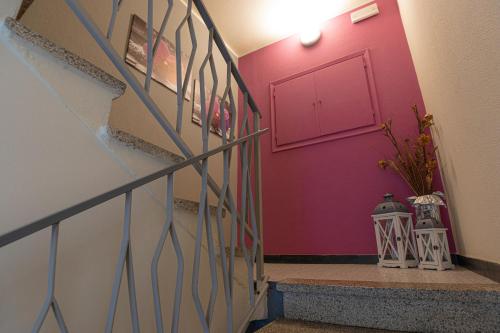 a hallway with a red door and a staircase at La Svolta in Chiuro