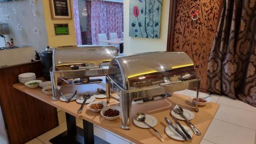 a restaurant counter with two silver food servers at The Park City Grand Plaza Kensington Hotel in London